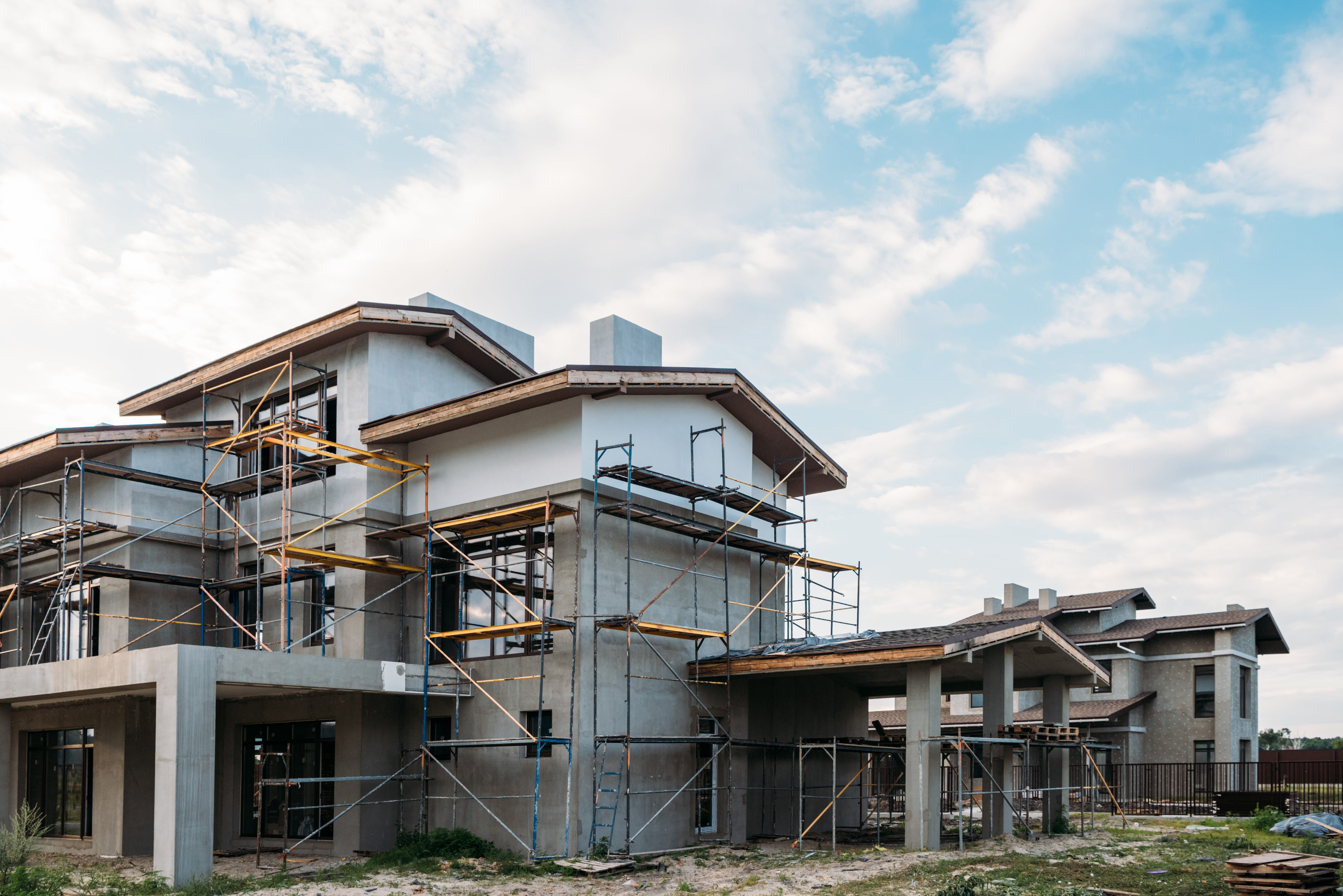 modern building construction with scaffolding under cloudy sky